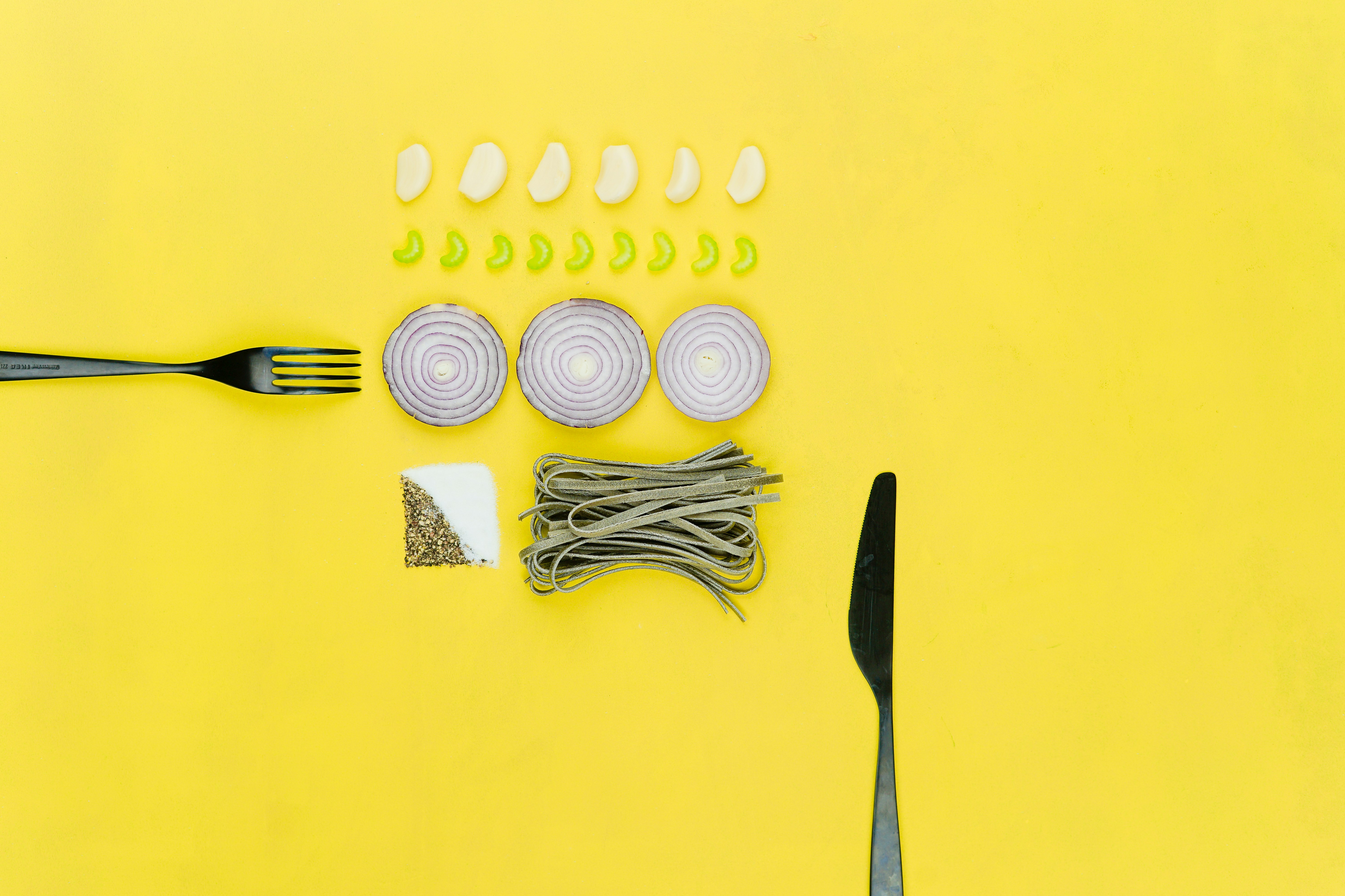 bread knife and sliced onion on yellow table